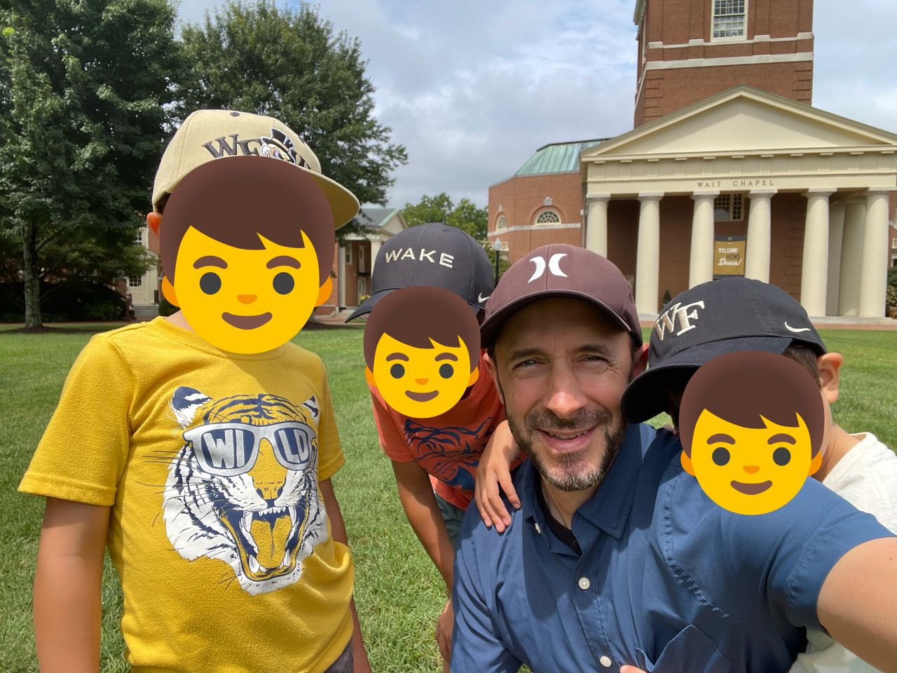 A selfie with three boys in Wake Forest hats on the quad in front of Wait Chapel at Wake Forest University.
