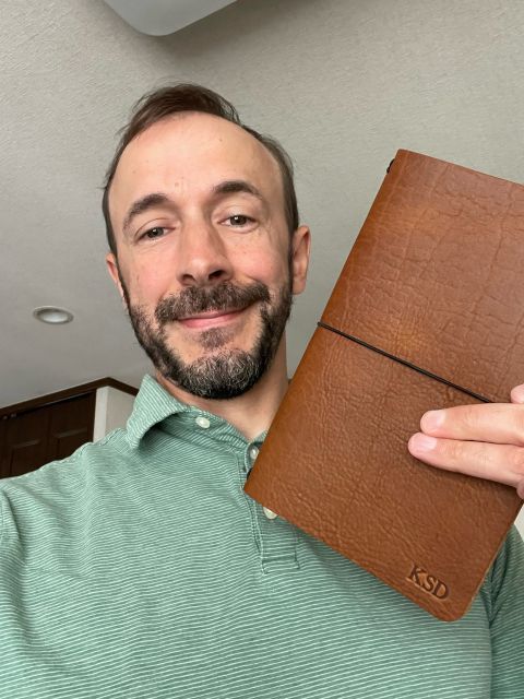 Holding a custom leather notebook embossed with my initials, KSD