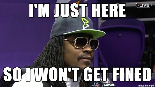 Marshawn Lynch meme: Lynch in a Seahawks cap and sunglasses at a press availability, captioned "I'm just here so I won't get fined."