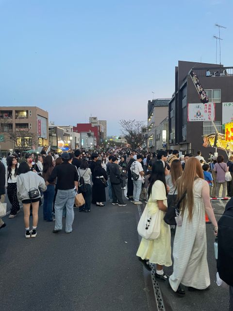A crowd filling a closed-off street in Oyama at dusk before the fireworks.