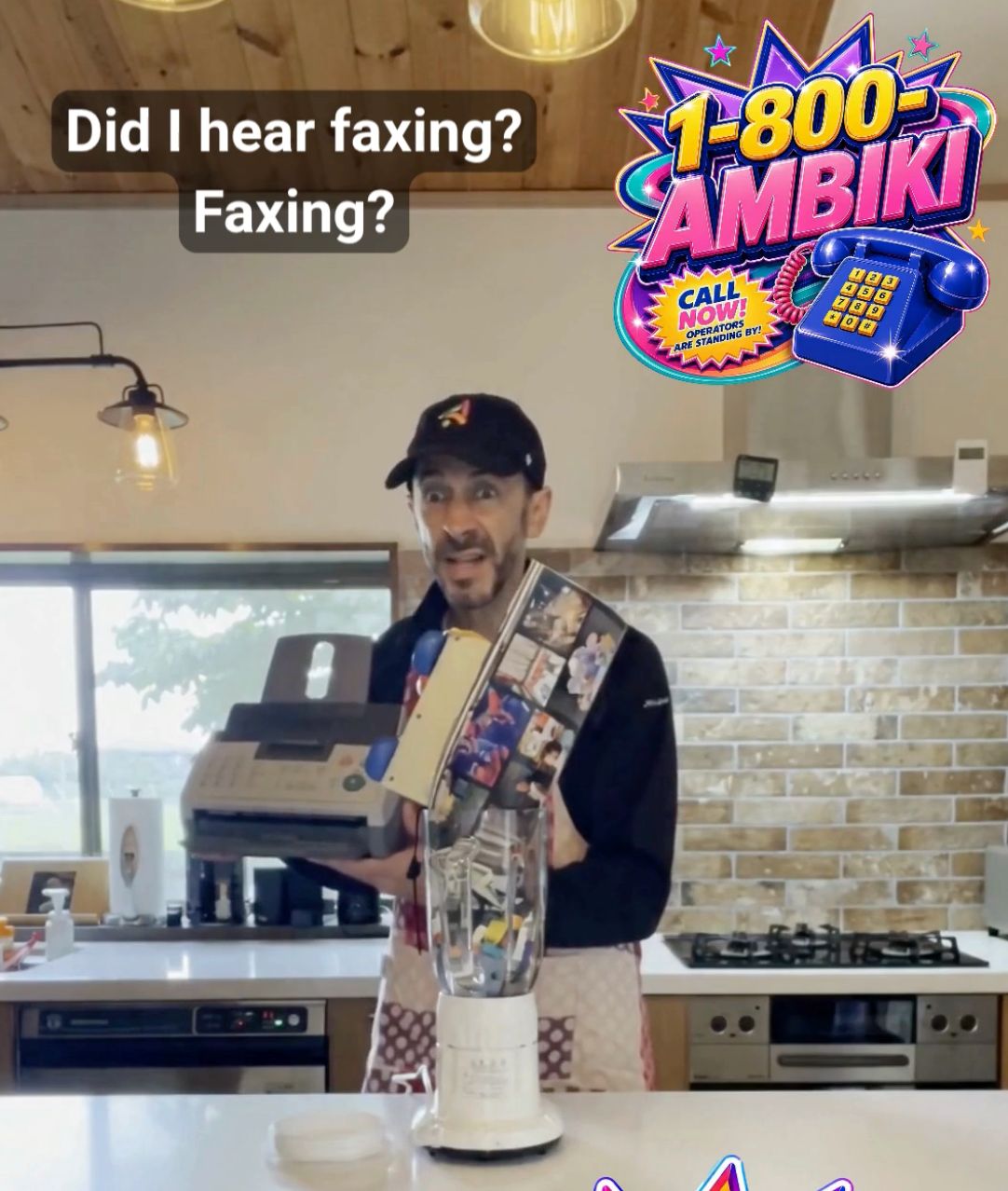 Kevin in a kitchen wearing an apron and an Ambiki hat, holding a fax machine over a blender with a shocked expression. Caption reads 'Did I hear faxing? Faxing?' with a 1-800-AMBIKI 'Call now, operators are standing by' graphic in the corner.