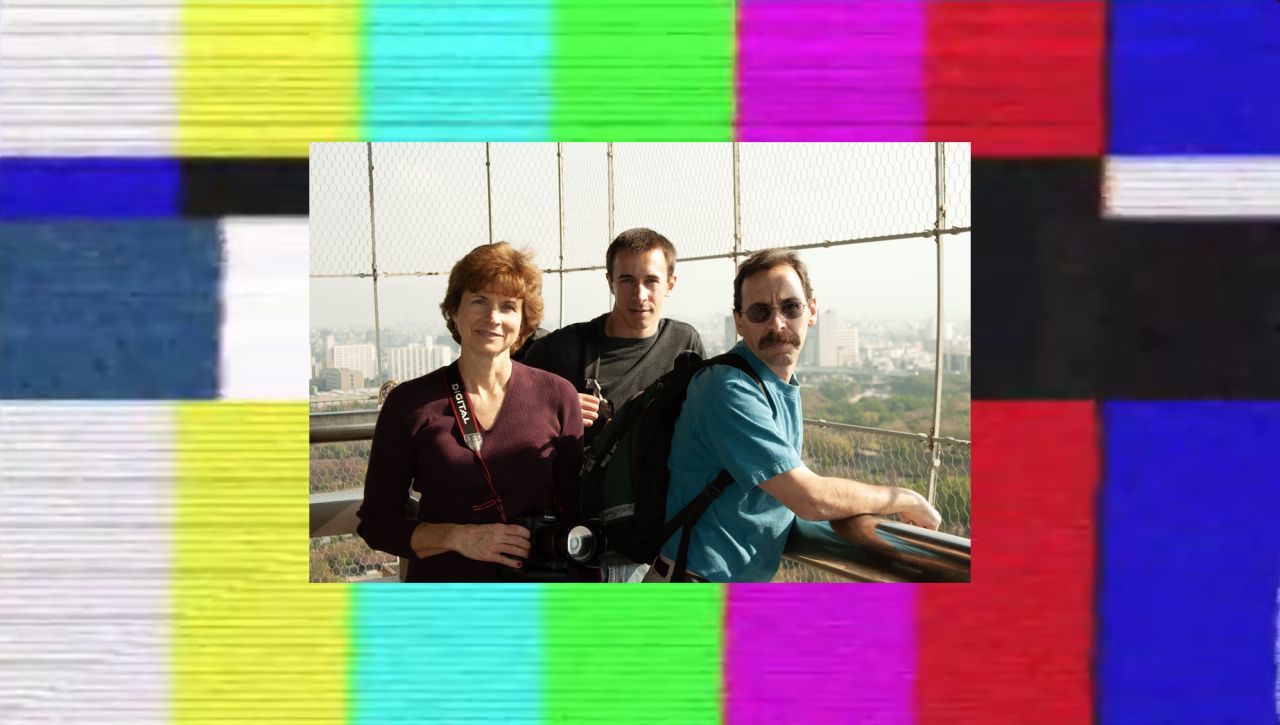 A family photo of a mother, son, and father on an observation deck, framed by a glitchy TV test pattern of color bars.